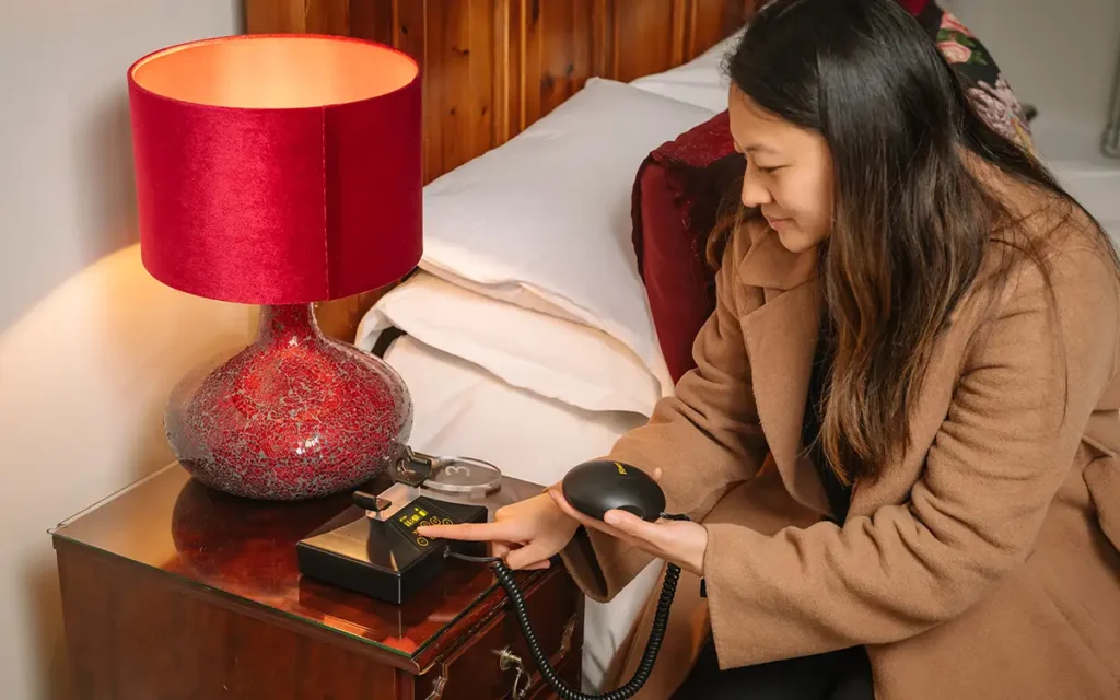 A hotel guest puts their Deafgard unit on a bedside table